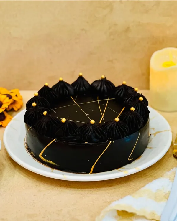 The Dutch Truffle cake is a timeless classic for a reason. This versatile cake, with its deep chocolate flavor and elegant finish, is perfect for any event. I decorate it with dark chocolate frosting and delicate gold accents for a touch of luxury.