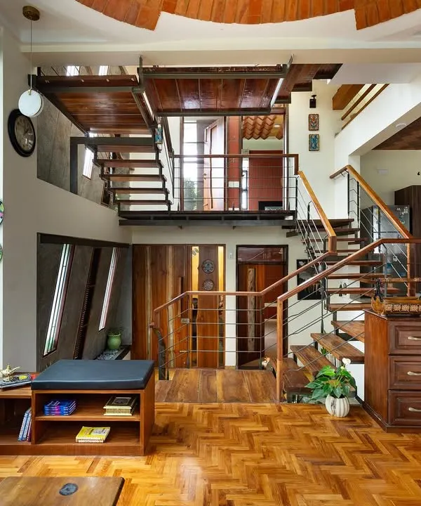 We design homes as interconnected stories, not just rooms. This view of a residence shows our use of organic geometry and natural materials like wood and stone to create a space that flows across multiple levels, always feeling open and connected.