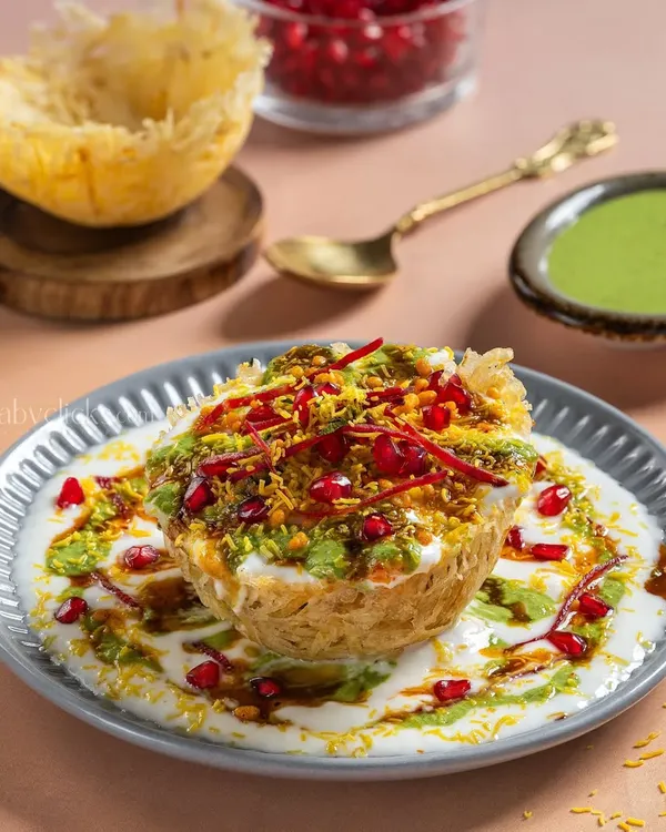 A stunning Raj Kachori from Gulab Sweets, overflowing with yogurt, chutneys, and sev. The styling makes it look like a royal street food dish.