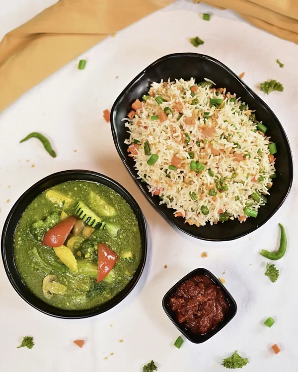 A perfect Indo-Chinese combo featuring our aromatic Burnt Garlic Fried Rice and vegetables in a vibrant green garlic sauce, served with a side of spicy chili paste.