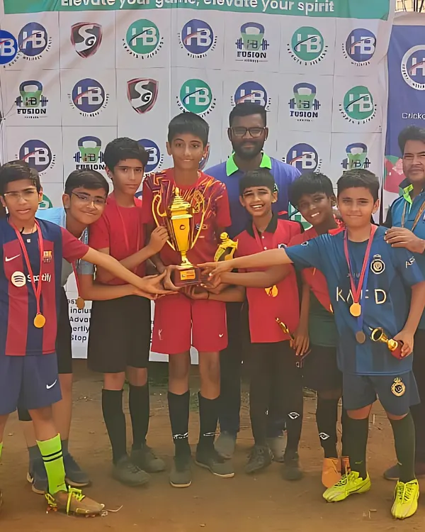 Champions of the turf. A young football team celebrates with their trophy after a hard-fought victory in a tournament organized by us.