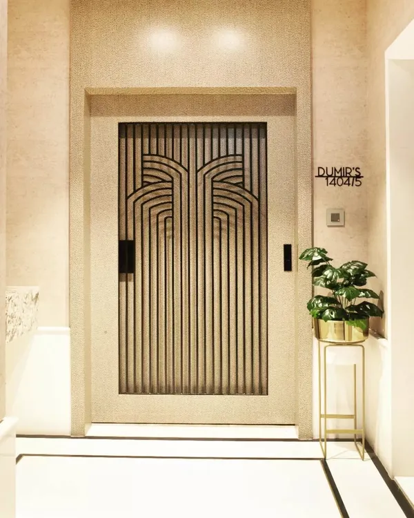 The entrance door to the Dumir's 5BHK apartment in Mulund. The Art Deco-inspired metal grillwork on the door makes a powerful first impression before you even step inside.