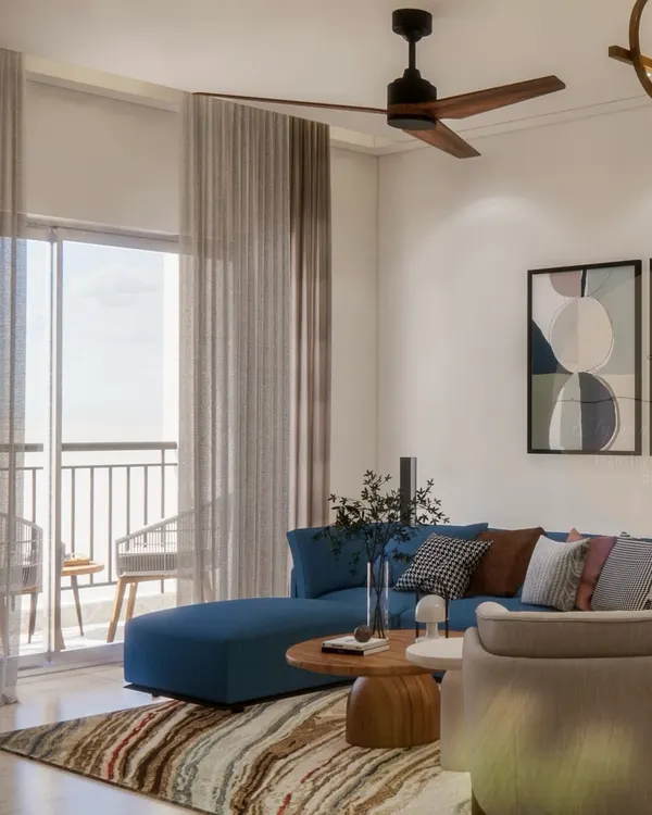 A look into the living area of our Prestige Waterford project. The deep blue L-shaped sofa adds a pop of color, while the sheer curtains allow for ample natural light, creating a space that is calm yet confident.