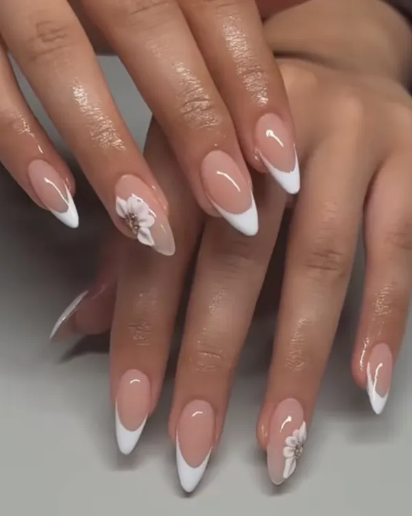 A classic French manicure with a delicate, hand-painted white flower. This is such a timeless and elegant look, perfect for any occasion.