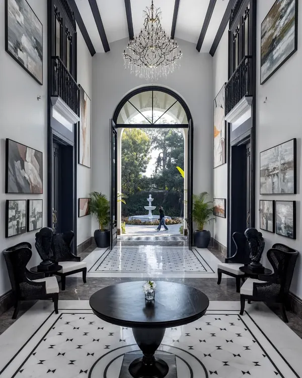 The vaulted entryway of the House of Verandahs creates a dramatic first impression, drawing the eye through the home to the gardens beyond. The design establishes long visual lines and a sense of symmetry, allowing light and movement to flow with ease.