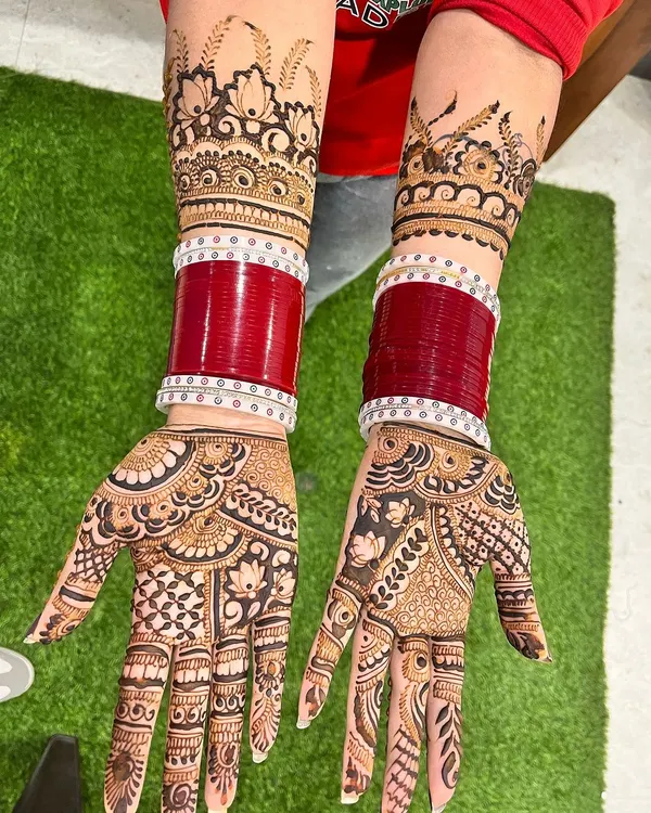 The perfect complement to the bridal chooda (bangles). This full-arm design features bold, traditional patterns with lotus and peacock elements, creating a stunning look for the bride.