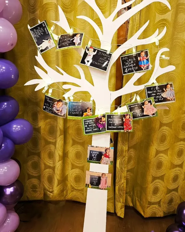 A creative way to display precious memories. I used this white tree prop with small clips and string lights to showcase a baby's monthly milestone photos at their first birthday party.