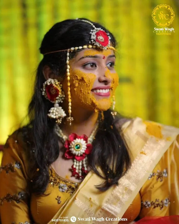 The quintessential Haldi glow. This bride looks absolutely stunning, her face bright with turmeric and her look completed by our red and white floral jewellery.