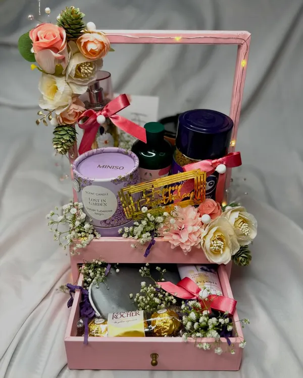 This drawer-style hamper is a perfect gift for her. The top holds a beautiful arrangement of self-care products, while the bottom drawer pulls out to reveal a secret stash of chocolates.
