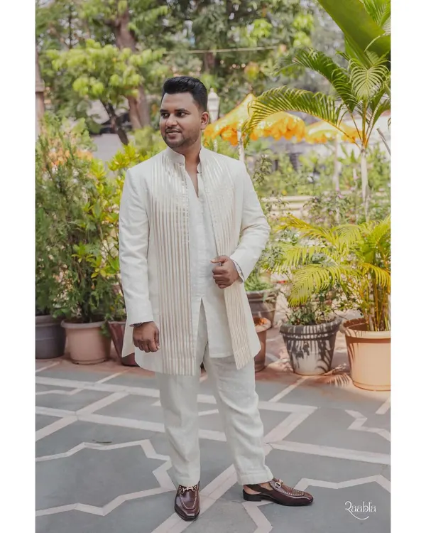 For this event, I designed a custom ivory kurta set for the groom, paired with a structured, striped jacket for a look that is both traditional and modern.