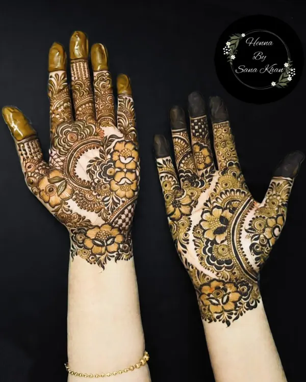 A beautiful example of my floral work, featuring a large central flower on the back of the hand, surrounded by delicate leaves and paisleys. The shading adds incredible depth.