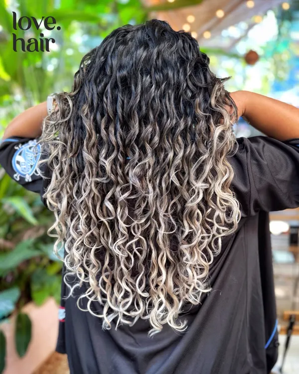 This is what we mean when we say we make curls the main character. We used a bleach and tone technique to get this stunning silver blonde, all while keeping the curl pattern healthy and defined with our specialized CGM styling.