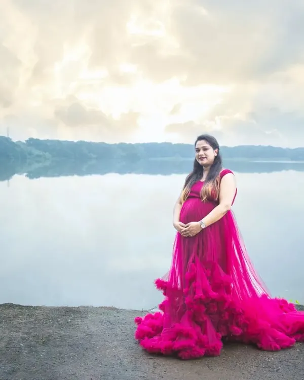 This is the moment to celebrate you. I love using dramatic, flowing gowns against serene natural backdrops like this lakeside, creating truly breathtaking portraits that capture the power and beauty of your pregnancy journey.