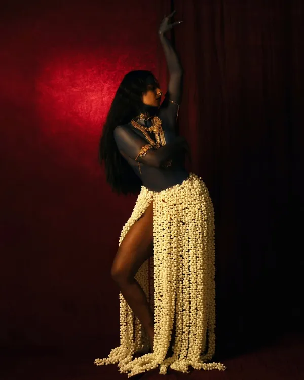 A conceptual shoot interpreting the fierce energy of the goddess Kali. The use of a skirt made of jasmine flowers and dramatic posing against a red backdrop creates a powerful visual narrative of destruction and creation.