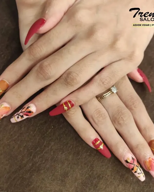 This set is a true work of art. On these long, dramatic stiletto nails, I combined matte red, warm brown, and intricate abstract floral patterns with gold foil accents for a bold and artistic statement.
