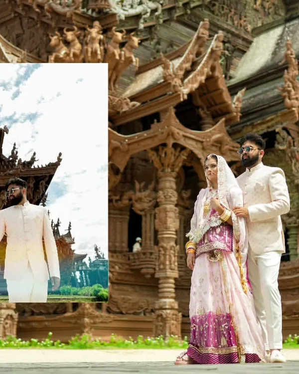 A grand portrait of a couple in traditional attire at the Sanctuary of Truth in Pattaya, Thailand, showcasing the scale of a destination shoot.