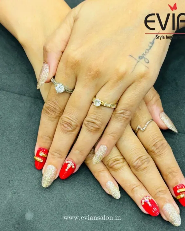 A detailed look at this festive nail set. You can see the texture of the full-coverage gold glitter nails next to the smooth red polish, accented with tiny rhinestones for extra sparkle.