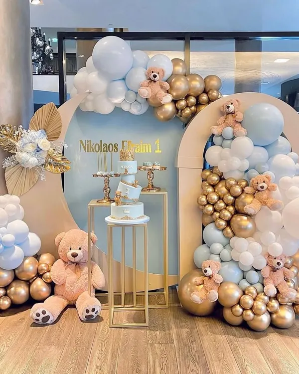 A beautiful teddy bear themed setup for a first birthday, perfect for a baby boy or girl. I designed this with a soft blue and gold color palette, using modern arched backdrops, organic balloon clouds, and multiple gold plinths for the cake and desserts. The large and small teddy bears add a warm, cuddly touch to the celebration.