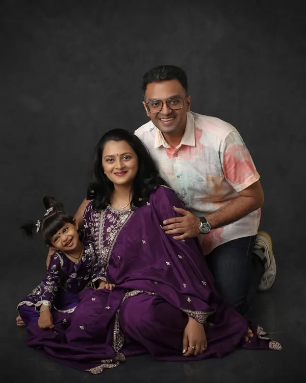 Every family has a story, and I love capturing yours. This beautiful studio portrait includes the couple's older daughter, all in matching purple, celebrating their growing family.