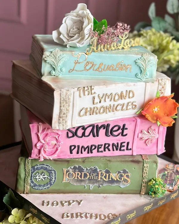 Turning pages and turning heads. This vintage books-themed cake is a story in every bite, featuring edible versions of favorite novels like 'Lord of the Rings' and 'Persuasion'.