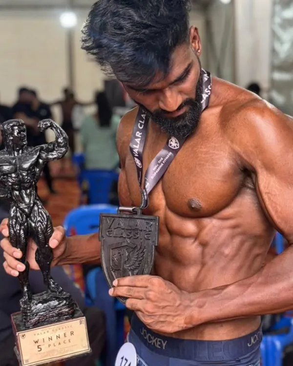 Holding the hardware. After going from zero to champion, this client proudly displays his trophy and medal from the Valarworld competition.