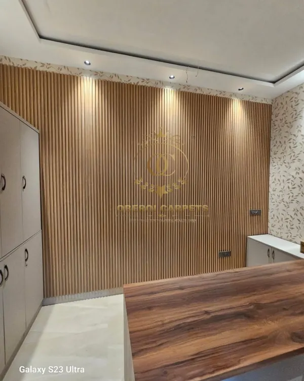 Here is a perfect example of how natural wood-finish WPC louvers can bring warmth and texture to an office or reception area. The vertical lines make the space feel taller, and the downlights highlight the beautiful panel details.