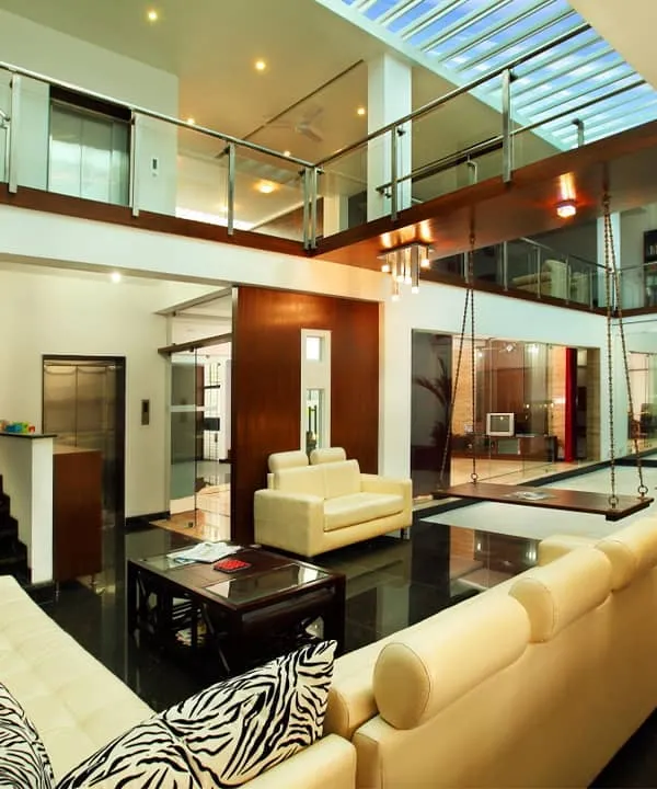 We designed this duplex residence around a central, double-height courtyard, crowned with a skylight to flood the home with natural light. The design establishes a constant visual connection between floors, creating a sense of immense volume and openness, with the indoor swing adding a touch of playful serenity.