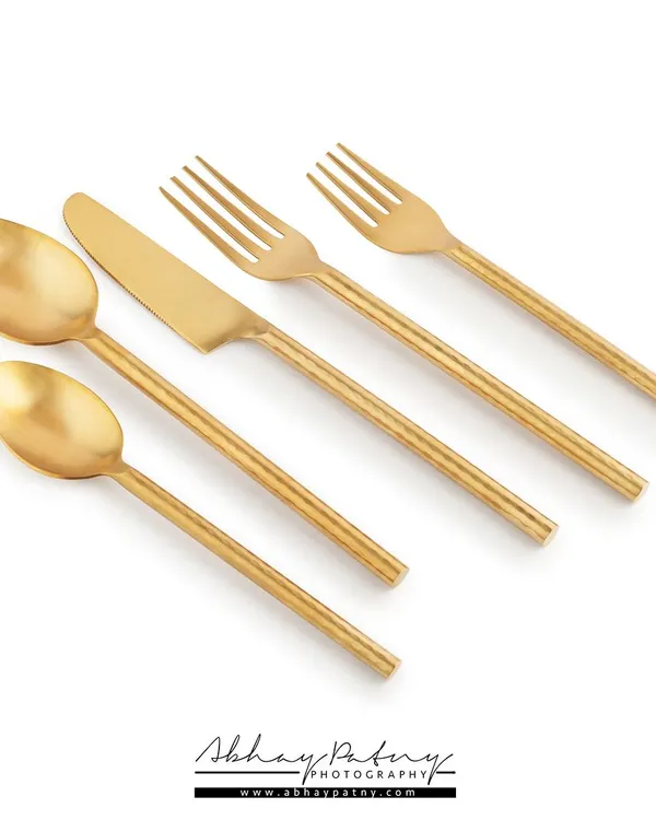 A clean, minimalist e-commerce shot of a golden cutlery set on a white background. This type of photography is essential for product listings on Amazon, Flipkart, or your own brand website.