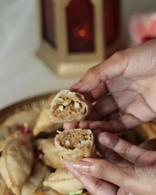 A cross-section of my Nutty Gujiya, showing the rich filling of homemade mawa, nuts, and coconut. Unlike traditional versions, mine are not soaked in sugar syrup, letting the natural flavors shine.