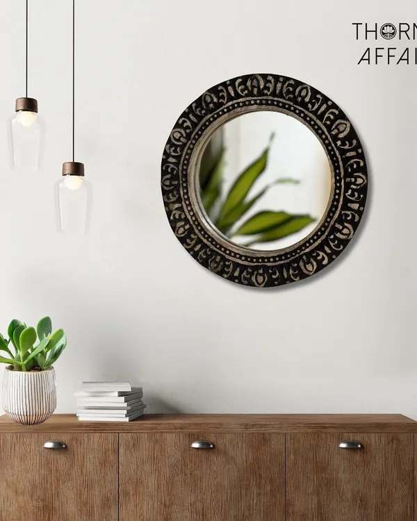 The classic round mirror, reimagined with traditional Indian carving. The dark finish on this mango wood frame adds a touch of rustic sophistication, making it a versatile piece that complements both modern and eclectic decor styles.