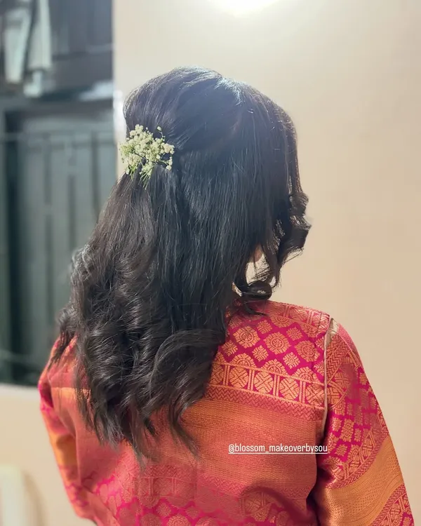 Soft, loose curls are a timeless choice for any special occasion. For this look, we did a simple half-up twist and added a small sprig of baby's breath for a touch of elegance.