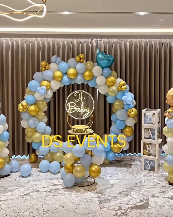 A classic "It's a Boy" baby shower theme. This setup includes a full balloon ring in blue and gold, themed props like a baby bottle balloon pillar, and "BABY" display boxes for a complete and joyful look.