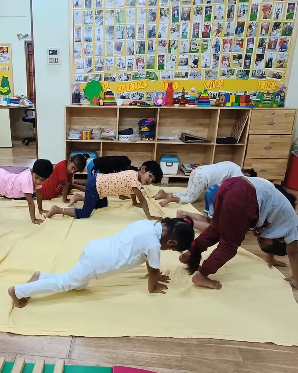 Our little Asters practice their plank and downward dog poses during a group yoga session. We make fitness fun by incorporating playful movements and poses.
