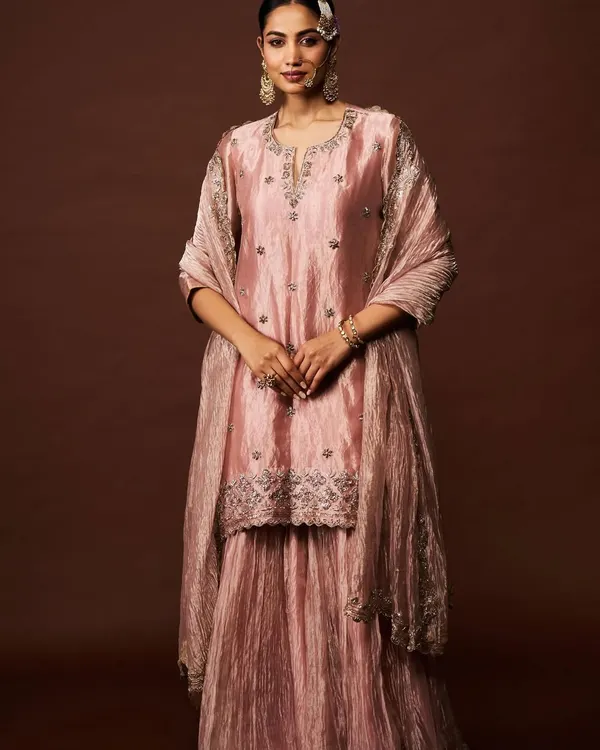 A vision in dusty rose. This shimmering sharara set with delicate silver embroidery exudes a quiet and sophisticated charm, perfect for any celebration.
