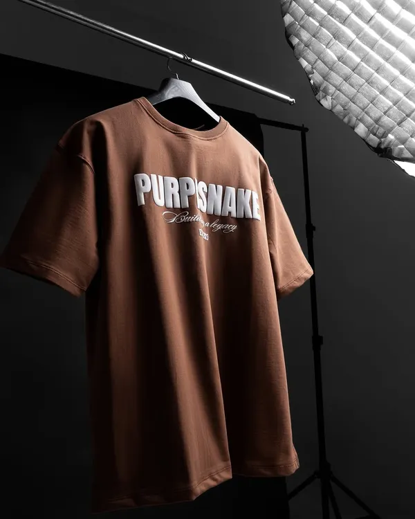 A behind-the-scenes look at a t-shirt shoot. We use professional lighting and a dark background to make the 3D puff-print logo on this brown t-shirt stand out.