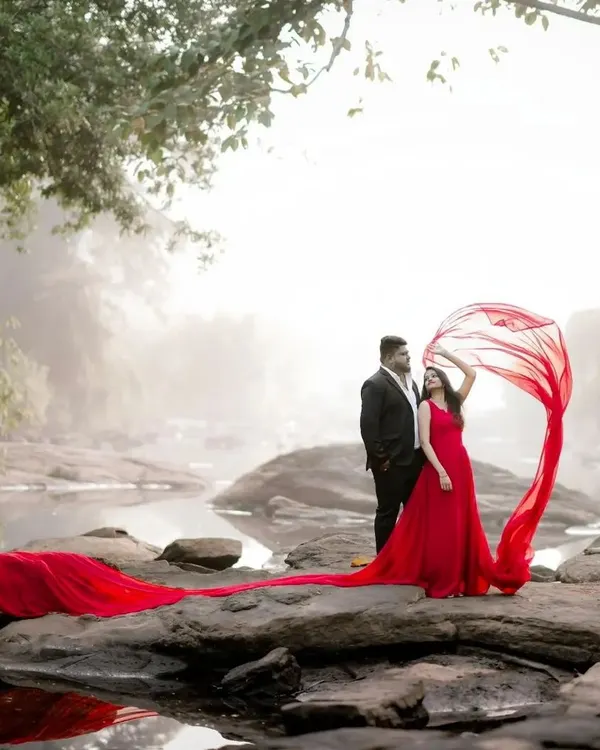 A perfect shot starts with the perfect dress. This vibrant red flying gown with a long trail creates a stunning contrast against the natural scenery, ideal for a dramatic pre-wedding photoshoot.