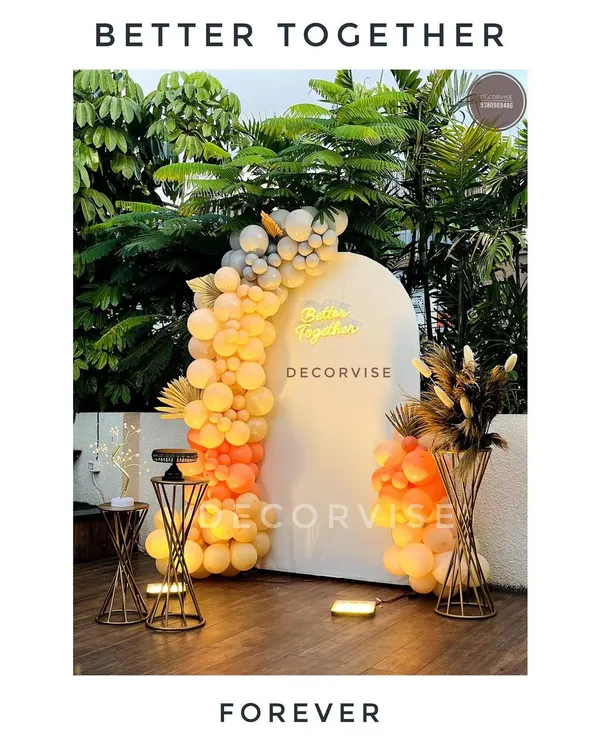 This modern backdrop is perfect for an engagement or anniversary. The warm-toned balloon garland and 'Better Together' neon sign create a romantic and stylish focal point for photos, especially in an outdoor or terrace setting.