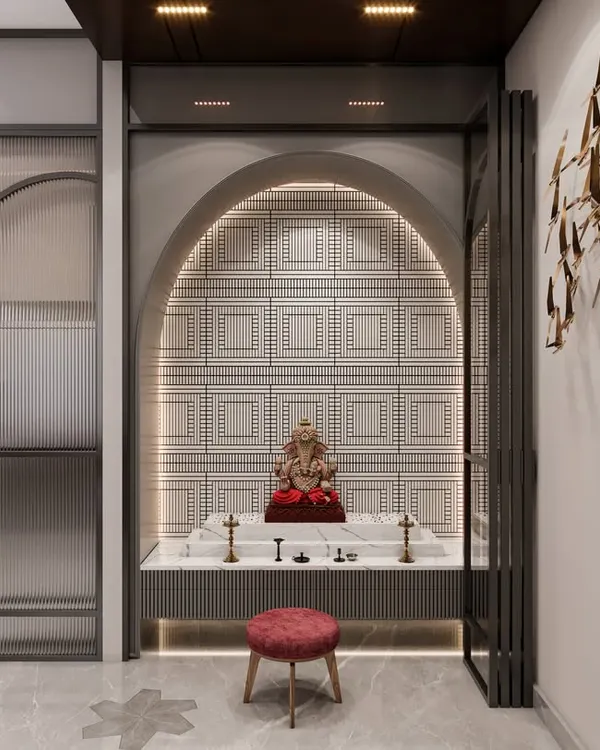 A beautiful pooja mandir set within an arched niche, featuring a backlit patterned wall and a Ganesha idol. The design uses folding doors to allow the space to be either open or enclosed, blending seamlessly with the home's modern interior.