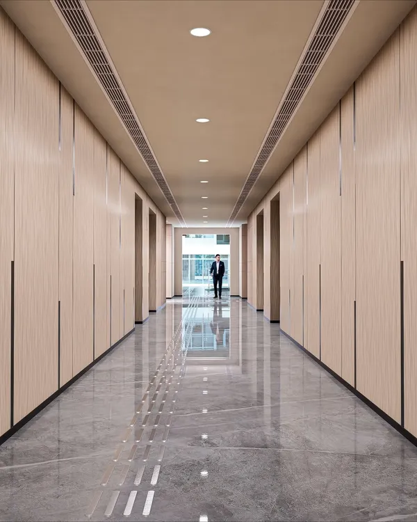 The elevator lobby at Brookfield, Candor TechSpace, designed for a feeling of contemporary elegance. The wood-paneled walls, polished marble floors with tactile paving, and clean lines create a sophisticated and seamless transition space.