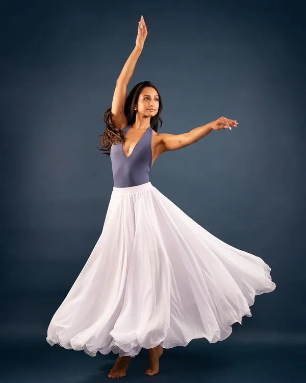 A studio portrait capturing the feeling of a 'swan song' through movement. The flowing skirt and graceful lines create a sense of elegance and flight.