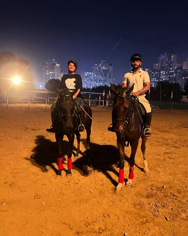 Two riders enjoy a night session in our well-lit arena, with the city lights providing a stunning backdrop.
