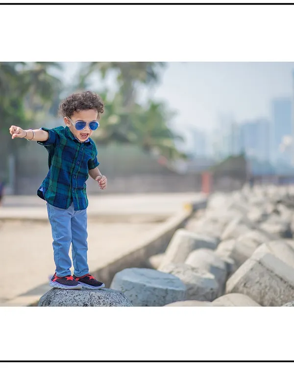 This little explorer is confidently navigating the rocks at the Mumbai seafront. Outdoor toddler photography is all about capturing their sense of adventure.