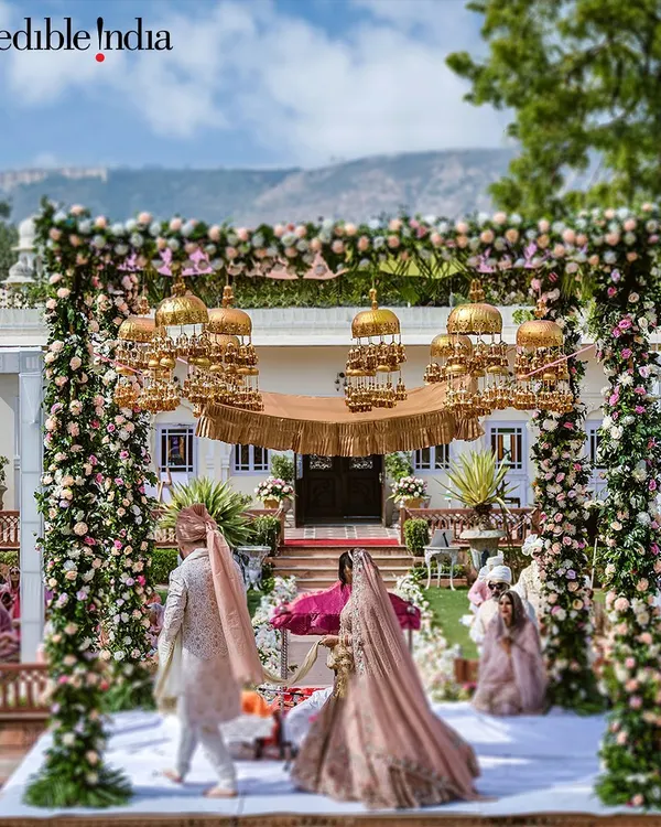 A shot of a grand floral mandap with golden kaleeras, featured by Incredible India to promote royal weddings in Jaipur.