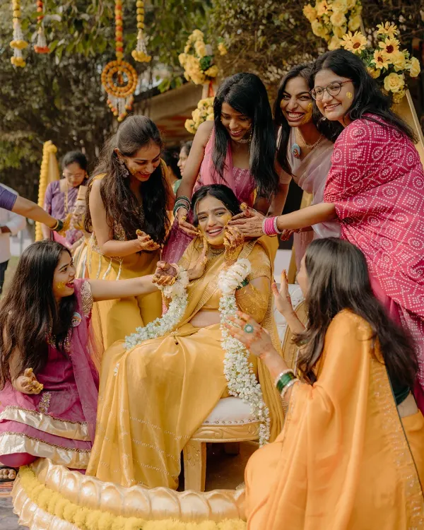 The bride surrounded by her best friends during the Haldi ceremony. This is a moment of pure joy and friendship, a memory to be cherished forever.