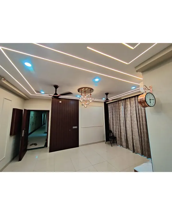 A close-up of a false ceiling design with multiple layers of cove lighting and a modern chandelier. This kind of lighting design adds depth, ambiance, and a sense of luxury to any room.