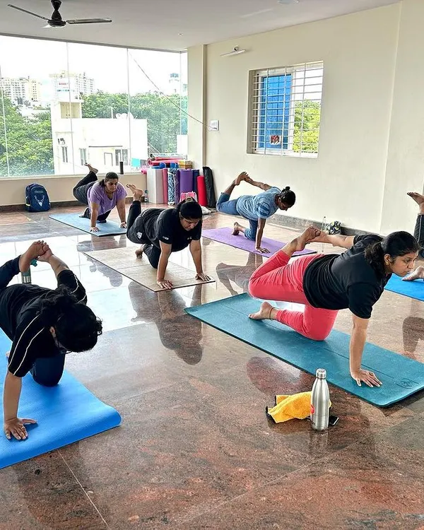 Students in our Bangalore studio moving through a balancing sequence. Each person is focused on their own practice, finding stability and strength in this dynamic kneeling pose.