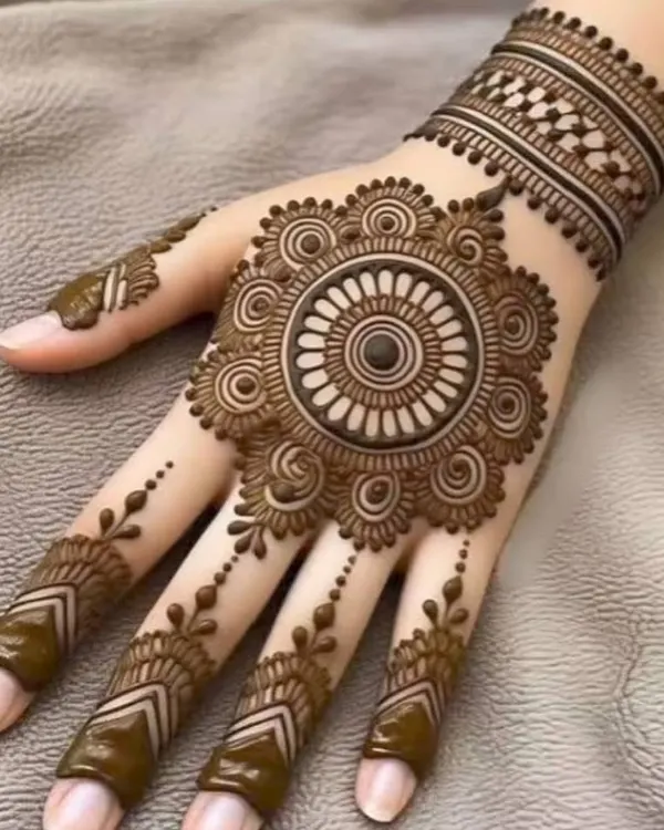 A perfect example of a classic mandala design. This circular pattern is centered on the back of the hand, with delicate dotted trails extending down the fingers. It's a timeless choice for any party or festival.