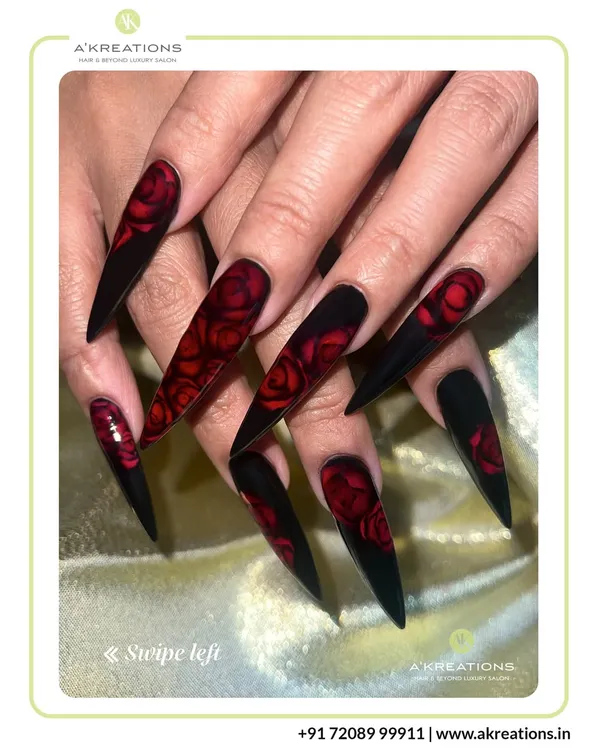 We craft dramatic stiletto nail extensions that serve as the perfect canvas for intricate art, like these hand-painted deep red roses on a striking black base.