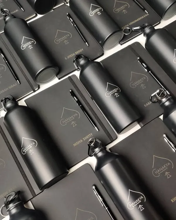 This is a great example of a complete onboarding kit I created for a corporate client. It includes a custom-branded notebook, a sleek metal pen, and a matching matte black bottle, all personalized for each new team member.