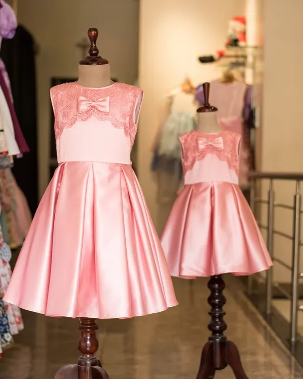 Double the elegance in these matching pink satin party dresses. Featuring a beautiful lace bodice and a full, pleated skirt, these are perfect for creating unforgettable sister moments at any special occasion.